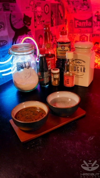 Unprocessed raw ingredients for Chow Mein in their packaging stand on a table. Two small bowls containing the sauce ingredients are in the foreground.