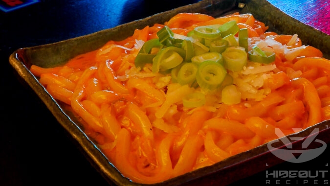 A futuristic Cyberpunk-style food photo showing a close-up of a plate of Gochujang Udon topped with grated parmesan and some scallions.
