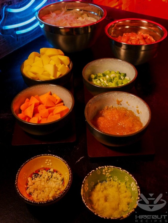 Raw, but portioned and processed ingredients, mostly vegetables, for Japanese chicken curry lie on a table.