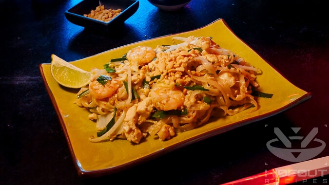 A futuristic Cyberpunk-style food photo showing a close-up of a plate of Pad Thai.