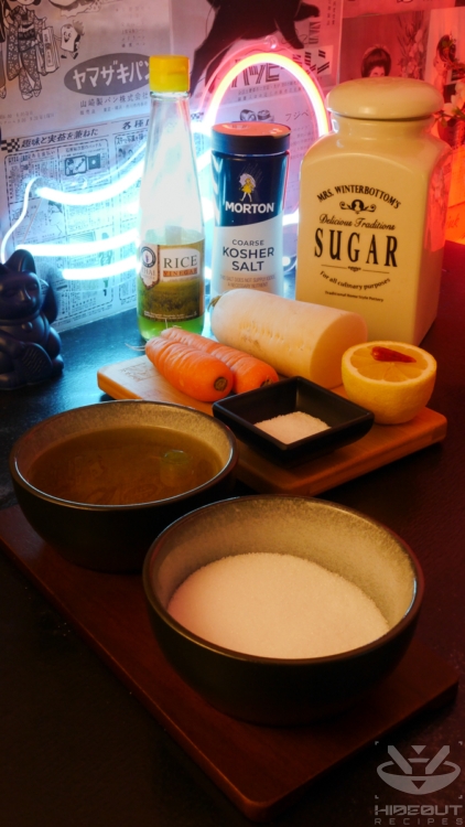 Pre-measured ingredients for pickled radish and carrots are distributed across a table.