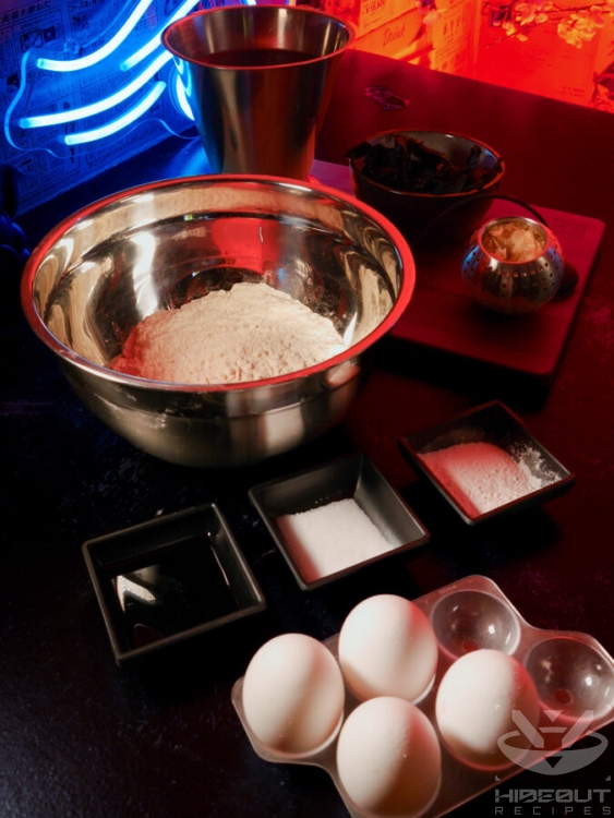 Pre-measured ingredients for Takoyaki batter are placed on a table, with ingredients for dashi visible in the background.