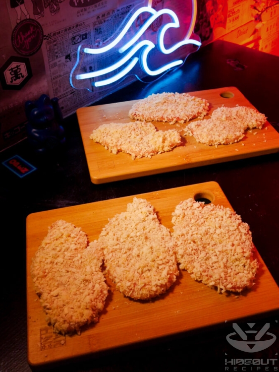 Six breaded Tonkatsu cutlets are distributed to wooden boards.