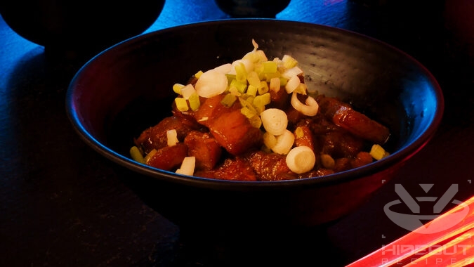 A futuristic Cyberpunk food photo showing a close-up of a bowl of oven-braised Kakuni (Japanese pork belly).