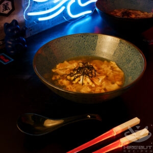 A futuristic Cyberpunk-style food photo. A bowl of Manduguk (Korean dumpling soup) can be seen next to a pair of glowing chopsticks.
