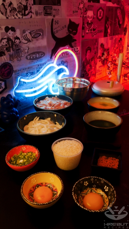 Pre-measured ingredients for Oyakodon are distributed across a table in small bowls, with an Oyakodon pan in the background.