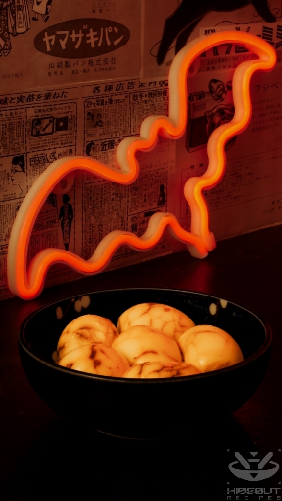 A bowl of Chinese Tea Eggs with a decorative bat LED for Halloween in the background.