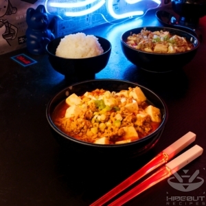 A futuristic Cyberpunk-style food photo showing two bowls of Chinese (Sichuan) Mapo Tofu with bowls of rice and a pair of glowing chopsticks in the foreground.