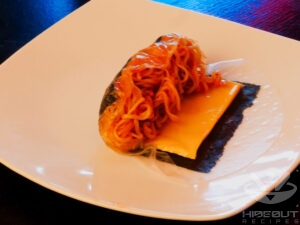 The second step of how the spring rolls are folded. A roll is half-folded starting on the side where the noodles are.