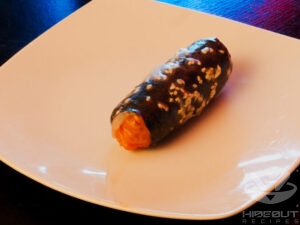 The final step of how the spring rolls are folded. A roll is lying on a table now fully folded.