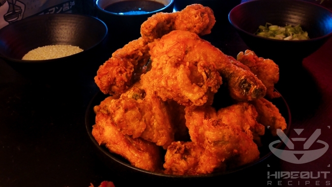 A futuristic Cyberpunk-style food photo. A pile of deep-fried Korean Fried Chicken is surrounded by Banchan and toppings.