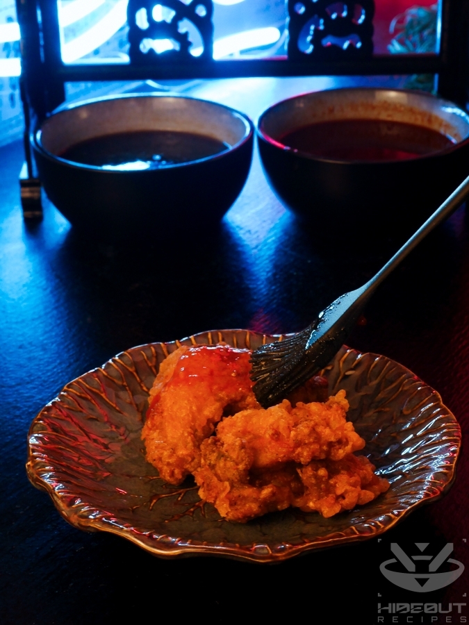 A silicone brush is being used to brush sauce on a piece of deep-fried Korean Fried Chicken.