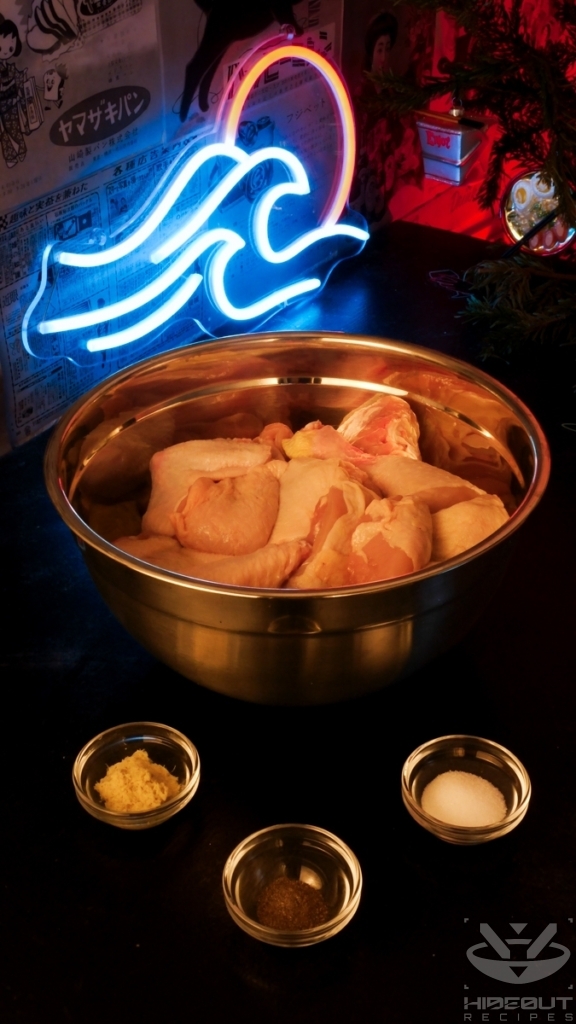 A large bowl of raw chicken is surrounded by three smaller bowls of ginger, black pepper, and salt.