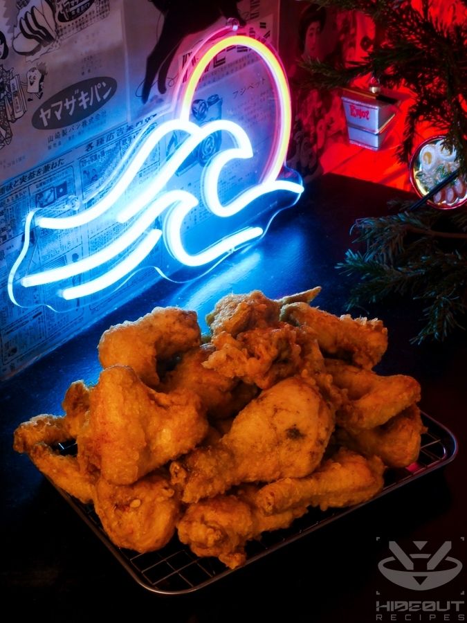 A batch of once-fried Korean Fried Chicken is waiting for the second fry on a wire rack.
