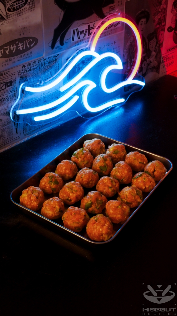 20 raw meatballs for bánh mì are neatly organized on a metal tray.