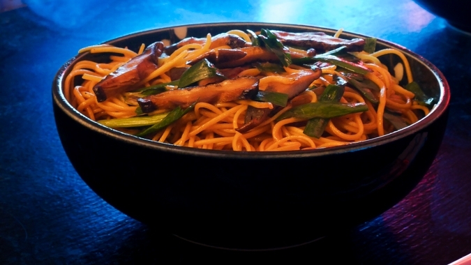 A futuristic Cyberpunk-style food photo showing a bowl of Yi Mein noodle stir-fry with shiitake mushrooms and Chinese chives.